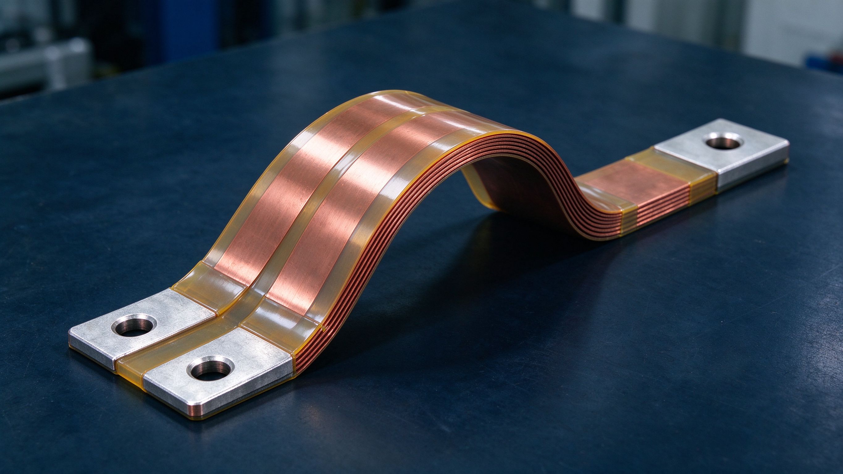 Flexible laminated busbar bent into a smooth arc